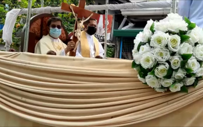 <p><strong>EASTER BLESSINGS</strong>. Bishop Ruperto Santos (left) of the Diocese of Balanga gives Easter Sunday blessings to Bataeños on board an open vehicle on Sunday (April 12, 2020). Holding a small cross with the crucified Christ, the prelate blessed every one he passed by from Samal town to Abucay and Balanga City. <em>(Photo by Ernie Esconde)</em></p>