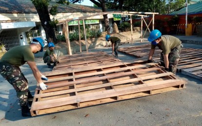 <p><strong>BUILDING PATIENT CARE CENTERS.</strong> Troops from engineering construction teams of the Philippine Air Force assist in building the coronavirus disease 2019 (Covid-19) patient care centers on Sunday (April 12, 2020). Each facility will be equipped with a nurse station, comfort room, shower room and a 15-bed capacity that can also accommodate suspect and probable Covid-19 patients. <em>(Photo courtesy of Air Force Public Affairs Office)</em></p>
