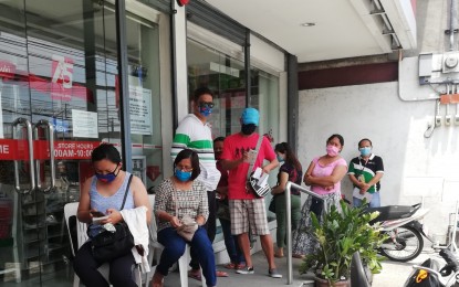 <p><strong>MANDATORY.</strong> Residents in Calasiao town wear face masks while waiting for their turn to enter an establishment on April 13, 2020. Provincial Ordinance No. 235-2020 requires every person in Pangasinan to wear a face mask at all times when going outside of their residence, at the workplace, when entering government buildings and offices, and while in public places. Violators face penalties. <em>(Photo courtesy of Enzo Navalta Austria)</em></p>