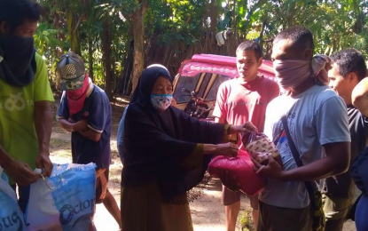 <p><strong>AIDING THE EVACUEES.</strong> Barangay officials of Bagoinged, Pagalungan, Maguindanao distribute relief food packs to some of the families displaced by "infighting" between two sub-commanders of the Moro Islamic Liberation Front in the border of Pagalungan and Pikit, North Cotabato on Monday (April 13, 2020). The conflict, which erupted over the weekend, was triggered by a "rido" (family feud) and has hurt six civilians and uprooted some 200 families in at least three adjoining villages. (<em>Photo courtesy of Pagalungan LGU)</em></p>