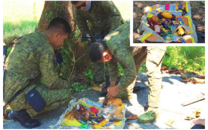 <p><strong>IMPROVISED BOMBS.</strong> Soldiers inspect the laminated sack that contained improvised bombs found on a roadside in Guindulungan, Maguindanao on Wednesday afternoon (April 15, 2020). The bombs (inset) are intended to harm soldiers and the civilians amid the enhanced community quarantine for the 2019 coronavirus disease in the province. <em>(Photo courtesy of 6ID)</em></p>