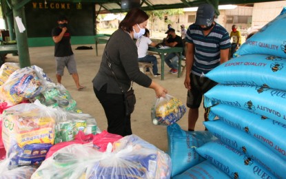 <p><strong>AID TO EX-REBELS.</strong> Silver Joy Tejano (left), OIC-chief of the Provincial Social Welfare and Development Office in Agusan del Norte, leads the distribution of rice and other food supplies to 22 former communist rebels at the headquarters of the Army's 23rd Infantry Battalion in Buenavista, Agusan del Norte, on Friday. Twenty-three other former rebels received similar aid at the headquarters of the Army's 29th Infantry Battalion in Cabadbaran City. <em>(PNA photo by Alexander Lopez)</em></p>