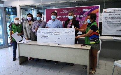 <p><strong>PCSO FUND FOR FRONT-LINERS.</strong> Philippine Charity Sweepstakes Office (PCSO) department manager Gloria Ybañez (right) turns over the check worth PHP30 million to Vicente Sotto Memorial Medical Center chief, Dr. Gerardo Aquino Jr. (third from right), as other hospital officials and PCSO-Cebu Manager Glen Jesus Rada look on. PCSO general manager Royina Marzan Garma enjoined government-owned and controlled corporations to help in the government’s battle against Covid-19 by donating funds for the protective equipment of front-liners. <em>(Photo courtesy of PCSO-Cebu)</em></p>