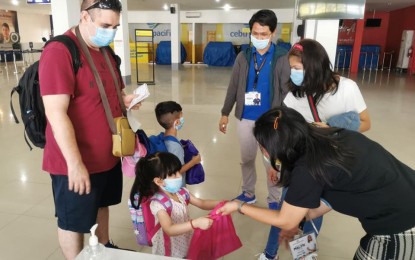 <p><strong>FLYING HOME AT LAST.</strong> Staff from the Department of Tourism hand tokens to tourists stranded by movement restrictions at the Tacloban Airport. Some 62 foreign tourists who were barred from travelling due to the health crisis left this city on Saturday (April 18, 2020) through a Cebu-bound sweeper flight. <em>(Photo courtesy of DOT Region 8)</em></p>
<p> </p>