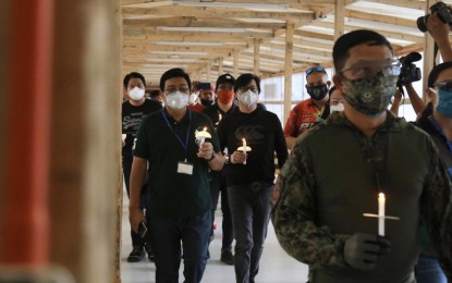 <p><strong>FIELD ISOLATION FACILITY.</strong> Cebu City Mayor Edgardo Labella (left) and Presidential Assistant for the Visayas, Secretary Michael Lloyd Dino (2nd from left), hold candles during the simple blessing of the Bayanihan Cebu Field Center-Sacred Heart School Ateneo de Cebu on Sunday (April 19, 2020). This field isolation facility for patients tested positive of coronavirus disease (Covid-19) is among the three being constructed to prepare Cebu City for a worst-case scenario. <em>(Photo courtesy of OPAV)</em></p>