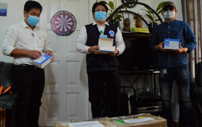 <p><strong>RAPID TEST KITS.</strong> Dr. Adriano Suba-an (center), Department of Health-10 director, receives the two boxes of rapid test kits donated by the office of Sen. Juan Miguel Zubiri Monday (April 20). The senator donated more than 6,000 test kits to health care facilities in some parts of Mindanao. With Suba-an is Dr. Ramon Nery (left), JR Borja General Hospital chief of hospital, and city councilor Zaldy Ocon. <em>(PNA photo by Jigger J. Jerusalem)</em></p>