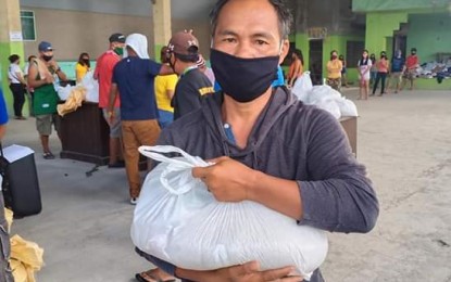 <p><strong>FOOD AID.</strong> Butuan City resident Sergio Sanchez is among the 736 beneficiaries who receive food packs from the city government Monday (April 20, 2020). The City Information Office of Butuan says the distribution of food packs will continue until the end of the week to all 86 barangays. <em>(Photo courtesy of Butuan City Information Office)</em></p>