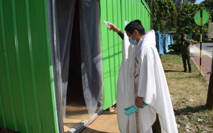 <p><strong>PATIENT CARE CENTERS.</strong> A military chaplain blesses two patient care centers in a turnover ceremony at the V. Luna General Hospital in Quezon City on Wednesday (April 22, 2020). These facilities were designed and constructed by the WTA Architecture + Design Studio, along with other architects and industry experts, and funded by the SM Foundation and Tayô, Táyo! Fundraiser. <em>(Photo courtesy of AFP Health Service Command)</em></p>