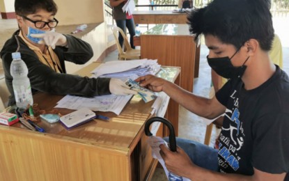 <p><strong>FINANCIAL AID.</strong> A staff of the Zamboanga City Social Welfare and Development Office hands over Tuesday (April 21) the PHP5,000 social amelioration pay to a beneficiary in Barangay Latuan. As of Tuesday, the CSWDO has already disbursed some PHP32.8 million to 6,587 family-beneficiaries.<em> (Photo courtesy of City Hall Public Information Office)</em></p>