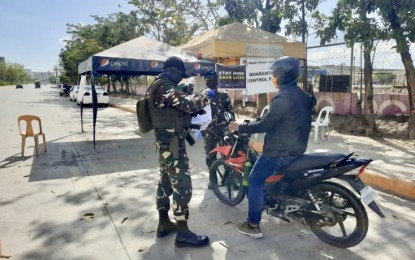 <p><strong>MANDAUE CONTROL POINT.</strong> Members of the Philippine Air Force based in Mactan Benito Ebuen Air Base check the papers of a motorcycle rider passing by the Mandaue City quarantine control point shared with Cebu City at the Mandaue Reclamation Area (MRA) on Thursday (April 23, 2020). The city government strictly enforces quarantine measures as the Department of Health (DOH-7) reported the first death due to Covid-19 in the locality.<em> (PNA photo by John Rey Saavedra)</em></p>
