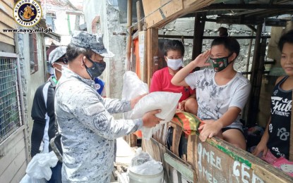 <p><strong>SNAPPY SALUTE.</strong> A teenager gives a salute to a Navy trooper helping in the distribution of food packs to Badjao communities in Dalahican, Cavite City on Monday (April 27, 2020). The food packs, which contain rice, dried fish, canned goods and instant coffee, were donated by the Ateneo De Manila University. <em>(Photo courtesy of Naval Public Affairs Office)</em></p>