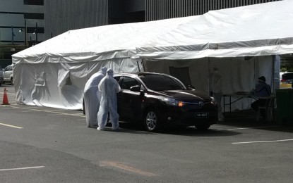 <p><strong>DRIVE-THRU TESTING.</strong> Health personnel from the city government of Taguig attend to a motorist availing of testing for Covid-19 at the city's first drive-thru testing center at the Bonifacio Global City on Wednesday (April 29, 2020). The measure is part of the city's Systematic Mass Approach to Responsible Testing (SMART) program aimed at preventing further spread of the disease. <em>(PNA photo by Lloyd Caliwan)</em></p>