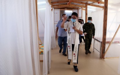 <p><strong>PATIENT CARE CENTER.</strong> A priest blesses the emergency quarantine facility at the Amang Rodriguez Memorial Medical Center in Marikina City in a turnover ceremony on Monday (May 4, 2020). The facility was turned to the hospital by the Armed Forces of the Philippines and the WTA Architecture+Design Studio. <em>(Photo courtesy of AFP Public Affairs Office)</em></p>