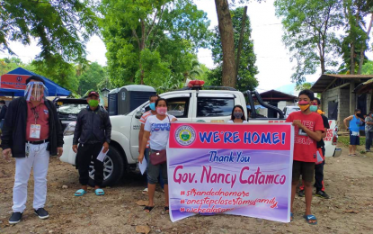 <p><strong>HOME AGAIN.</strong> The family of Wesleyan Church Pastor Juanito Rivera Guilon (2nd from left) holds a tarp on Monday (May 4, 2020) to show their appreciation for North Cotabato Governor Nancy Catamco’s efforts to bring them back home. The pastor’s group was the first batch of some 4,000 North Cotabateños who have expressed their desire to go home after being caught in lockdowns in various parts of the country due to the Covid-19 crisis. <em>(Photo courtesy of North Cotabato PIO)</em></p>