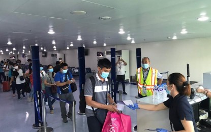 <p><strong>HOME AT LAST.</strong> Overseas Filipino workers (OFWs) present tickets before boarding a Philippine Airlines’ sweeper flight bound for Cagayan de Oro at the Clark International Airport on Saturday (May 9, 2020). The 21 OFWs received certifications of quarantine completion after testing negative for coronavirus disease 2019. <em>(Contributed photo)</em></p>