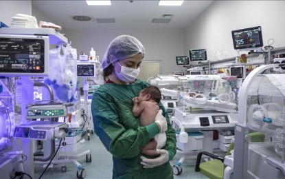 <p><strong>PROTECTED</strong>. A nurse wearing protective equipment holds a newborn at the neonatal intensive care unit of the Martyr Prof. Dr. Ilhan Varank Training and Research Hospital in Istanbul, Turkey on Tuesday (May 12, 2020). Nurses of the unit are being fitted with face shields, protective masks, and gloves to protect babies from the Covid-19 pandemic. Besides the Covid-19 unit, the emergency service, intensive care, and neonatal intensive care are in service in Martyr Prof. Dr. Ilhan Varank Training and Research Hospital.<em> (Şebnem Coşkun - Anadolu Agency )</em></p>