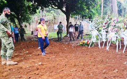 <p><strong>MOTHER’S LOVE.</strong> Emily Hiponia (in yellow shirt), together with 1Lt. Roel Maglalang (left), civil-military operations officer of the Army's 23rd Infantry Battalion, visits the public cemetery in Sitio Lingcomonan, Barangay Binakalan, Gingoog City on Friday (May 15, 2020), where her daughter Gladys Joy and eight other communist New People's Army rebels were buried. The rebels were killed in an encounter along the border of Agusan del Norte and Misamis Oriental last May 10. <em>(Photo courtesy 23IB)</em><br /><br /><br /><br /></p>
