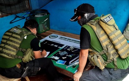 <p><strong>SHABU SEIZED.</strong> Philippine Drug Enforcement Agency agents in Region-10 inspect the pieces of evidence after five drug suspects are arrested inside an alleged drug den in Linamon town in Lanao del Norte on Saturday (May 16, 2020). PDEA-10 says the five sealed plastic sachets of suspected shabu are estimated to be worth PHP136,000. <em>(PNA photo by Richel V. Umel)</em></p>
