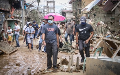 <p><strong>MUDDY STREET.</strong> Eastern Samar Governor Ben Evardone (left) and other local officials walk on a muddy street in Jipapad, Eastern Samar in this May 16, 2020 photo or two days after the typhoon that brought heavy flooding. The Eastern Samar provincial government has placed on Tuesday (May 19, 2020) the nine towns in the province under state of calamity due to damages caused by Typhoon Ambo. <em>(Photo courtesy of Eastern Samar Governor Ben Evardone)</em></p>