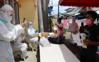 <p><strong>HIGH-RISK AREA.</strong> Donning their personal protective equipment, personnel of the Department of Social Welfare and Development (DSWD) 11 (Davao region) brave the front lines to distribute the government's emergency cash aid in Barangay 23-C, Davao City, which is considered a “very high-risk” area due to its high number of Covid-19 cases. DSWD-11 assured on Friday (May 22, 2020) that it would continue distributing the emergency cash aid and other government assistance despite the risks.<em> (Photo courtesy of DSWD-11)</em></p>