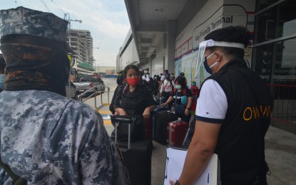 <p><strong>ON THE WAY HOME.</strong> Personnel from the Philippine Coast Guard and the Overseas Workers Welfare Administration assist overseas Filipino workers heading home to their respective provinces during a send-off at the Parañaque Integrated Terminal Exchange on Monday (May 25, 2020). The Department of Labor and Employment vowed to send home around 24,000 OFWs stuck in quarantine centers in Metro Manila within the next three days upon the instructions of President Rodrigo Duterte.<em> (PNA photo by Avito C. Dalan)</em></p>