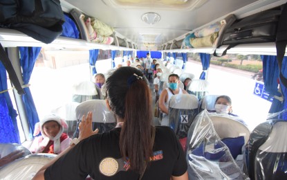 <p><strong>SWEEPER BUS.</strong> Department of Tourism Region 8 Director Karina Rosa Tiopes and a member of the regional office response team brief the passengers on protocols such as social distancing inside the bus shortly before departure. The tourists — 74 boarded four sweeper buses and 10 rode their own vehicles, expressed relief for the trip back home after being stranded in the region since the start of the travel restrictions due to the enhanced community quarantine.<em> (DOT photo)</em></p>