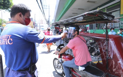 <p><strong>QUARANTINE PROTOCOL.</strong> Traffic enforcer checks the body temperature of a tricycle driver using thermal scanner at the Agora Terminal in San Juan City, Metro Manila on Thursday (May 28, 2020). Malacañang urged the public to cooperate with government authorities as Metro Manila and other areas shift to more relaxed community quarantine against coronavirus on Monday (June 1). <em>(PNA photo by Joey O. Razon)</em></p>