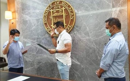 <p><strong>OATH OF OFFICE.</strong> Erstwhile Vice Mayor Jose Santiago Jr. takes his oath of office as the new mayor of Bocaue, Bulacan before Governor Daniel Fernando as witnessed by Darwin David, provincial director of Department of the Interior and Local Government (DILG) at the Office of the Governor in the City of Malolos on Monday (June 1, 2020). Santiago became mayor by succession following the untimely death of Mayor Eleanor "Joni" Villanueva-Tugna. <em>(Photo courtesy of DILG-Bulacan)</em></p>