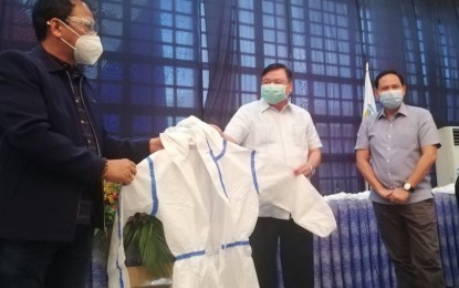 <p><strong>PPE SUPPLY.</strong> Secretary Carlito Galvez (left), the chief implementer of the National Action Plan on Covid-19, turns over personal protective equipment (PPE) to Iloilo City Mayor Jerry Treñas (center) and Iloilo Governor Arthur Defensor Jr. during a meeting at the Casa Real de Iloilo on Tuesday (June 2, 2020). Galvez praised the coronavirus disease 2019 (Covid-19) response efforts of Western Visayas. <em>(PNA photo by Gail Momblan)</em></p>