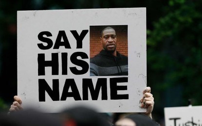 <p>A protester carries a placard bearing George Floyd's photo<em> (Anadolu photo)</em></p>