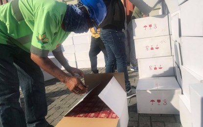 <p><strong>INTERCEPTED.</strong> A Bureau of Customs employee inspects on Wednesday afternoon (June 3, 2020) one of the boxes containing smuggled cigarettes from Vietnam worth PHP5.9 million seized at the Makar port in General Santos City. The contraband declared as paper board based on shipping documents was intercepted in coordination with the Interpol in Manila. <em>(PNA photo by Richelyn Gubalani)</em></p>
