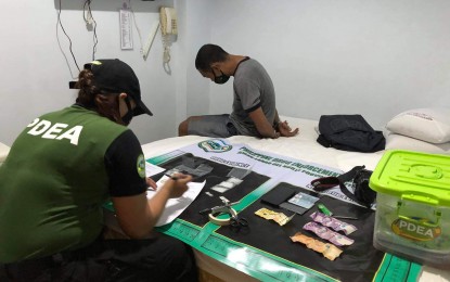 <p><strong>BUSTED.</strong> An operative of the Philippine Drug Enforcement Agency conducts an inventory of the pieces of evidence seized from an alleged illegal drug seller who introduced himself as an active member of the Philippine Army during a buy-bust operation in Barangay San Miguel, Iligan City on Friday evening (June 5, 2020). The Army's 1st Infantry Division clarified that the suspect, Mcrome Lozada, had been booted out of service since April for unspecified offenses. <em>(Contributed photo)</em></p>