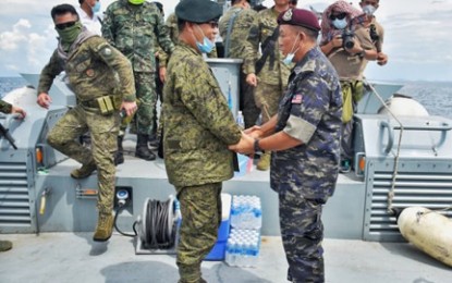 <p><strong>INNOCENT.</strong> Lt. Gen. Cirilito Sobejana, Western Mindanao Command chief (left), and Deputy Commission of Police Dato' Hazani Bin Ghazali, chief of the Eastern Sabah Security Command (right), meet on Sunday (June 7, 2020) at the maritime border of Philippines and Malaysia. Hazani turned over to Sobejana the three Filipinos they recently arrested while drifting at sea near Tambisan Island, Lahad Datu, Malaysia. <em>(Photo courtesy of Westmincom PIO)</em></p>