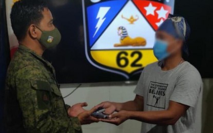 <p><strong>SURRENDER.</strong> “Ka Dodong” turns over a .45-caliber pistol with two magazines and 25 serviceable ammunition to Lt. Col. Melvin Flores, commander of Philippine Army’s 62nd Infantry Battalion. He surrendered along with his partner “Ka Lara” to government troops at the battalion’s headquarters in Barangay Libas, Isabela, Negros Occidental on Sunday, June 14, 2020. <em>(Photo courtesy of 62nd Infantry Battalion, Philippine Army)</em></p>