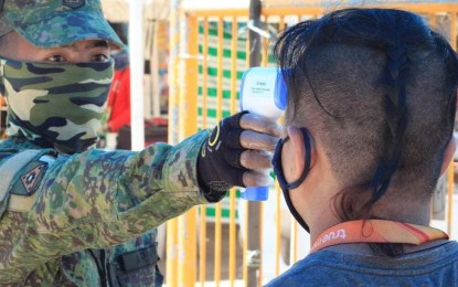 <p><strong>ROLE MODEL</strong>. An Army reservist checks the temperature of a passerby in a quarantine control point in Lapu-Lapu City, Cebu, in an undated photo. Lt. Col. Rowel Gavilanes, director of the 701st Community Defense Center (CDC) of the Army Reserve Command, on Thursday (June 18, 2020) said reservists in Cebu City where Covid-19 cases are rising can help the city government in enforcing health and safety protocols by monitoring compliance with health and safety protocols in their own community<em>. (Photo courtesy of 1Lt. Ronald Cabiles)</em></p>