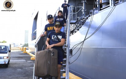 <p><strong>ON THE WAY HOME.</strong> Navy personnel help carry the luggage of a repatriate while disembarking from the BRP Davao del Sur at Pier 15, South Harbor in Manila on Wednesday (June 17, 2020). The Navy has started transporting some of the OFWs and tourists who were repatriated from India and Sri Lanka back to their hometowns after they have completed the mandatory quarantine and have tested negative for Covid-19. <em>(Photo courtesy of the Naval Public Affairs Office)</em></p>