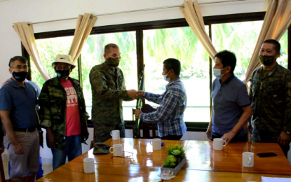 <p><strong>PEACE PARTNER.</strong> Former Moro Islamic Liberation Front commander Sambutuan Sanday (in striped long sleeves) hands over his rifle to Brigadier Gen. Roberto Capulong, the Army’s 602nd brigade commander, during a surrender ceremony on Wednesday (June 17, 2020) in Pikit, North Cotabato. Sanday vowed to work with the government to attain peace in troubled Moro communities. <em>(Photo courtesy of 602Bde)</em></p>