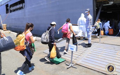 <p><strong>PROVINCE BOUND</strong>. Locally stranded individuals (LSIs) bound for Cebu and Iloilo get on board the BRP Davao Del Sur at Pier 13, Manila South Harbor on Sunday (June 21, 2020). Malacañang on Tuesday (June 23) said LSIs and repatriated overseas Filipino workers (OFWs) will be sent to their respective provinces before deciding on when to allow provincial buses to operate.<em> (Photo courtesy of Philippine Navy Public Affairs Office)</em></p>