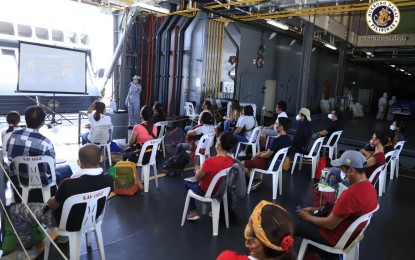 <p><strong>STRANDED INDIVIDUALS</strong>. Locally stranded individuals (LSIs) attend shipboard briefing after they get on board the BRP Davao Del Sur at Pier 13, Manila South Harbor on Sunday (June 21, 2020). The Philippine Navy ship will sail on Monday to transport 450 LSIs to Cebu and Iloilo.<em> (Photo courtesy of PN)</em></p>