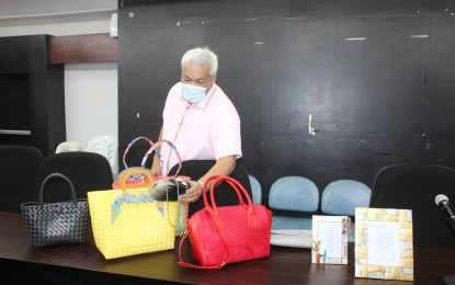 <p><strong>BUSINESS AID</strong>. Mayor Carmelo Lazatin Jr. checks on some locally made products displayed at the One Town One Product (OTOP) souvenir center in Angeles City, Pampanga in an undated photo. The city government has offered use of the center to micro, small and medium enterprises (MSMEs) to promote their merchandise to help them recover from the adverse economic effects of the Covid-19 health crisis.<em> (Photo by the City Government of Angeles)</em></p>