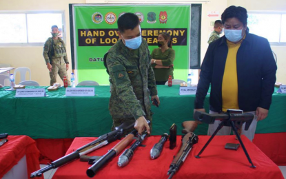 <p><strong>SURRENDERED GUNS.</strong> Col. Rico Jesus Atencio (left), commander of the Army’s 1st Mechanized Infantry Battalion, inspects one of the rifles surrendered by the local government of Datu Unsay, Maguindanao as Mayor Datu Andal Ampatuan V looks on. The local government unit turned over nine assorted firearms collected from unlicensed gun holders in the area. <em>(Photo courtesy of 6ID)</em></p>