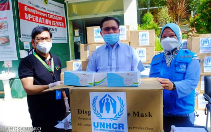 <p><strong>DONATIONS</strong>. Bangsamoro Autonomous Region in Muslim Mindanao Chief Minister Ahod Ebrahim (center), together with Interior Minister Naguib Sinarimbo (left) accepts the anti-Covid-19 equipment and supplies donation from Sapia Taulani (right), senior protection associate of the UN High Commissioner for Refugees, during turnover rites held at the BARMM administrative center in Cotabato City on Friday (June 26, 2020). The donation included plastic tarpaulins with eyelets, N95 masks, patient care gloves, surgical caps, shoe covers, medical masks, and face shields.<em> (Photo courtesy of BPI-BARMM)</em></p>