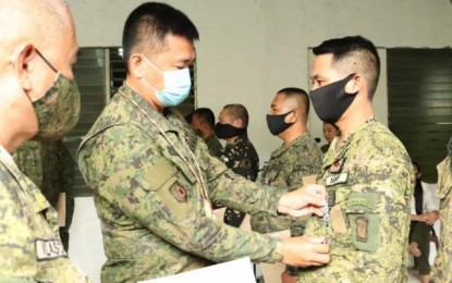 <p><strong>COMMENDATION</strong>. Col. Inocencio Pasaporte (center), commander of the 303rd Infantry Brigade, pins the Military Commendation Medal on an Army reservist during the awarding ceremony held at the headquarters of the 605th Community Defense Center in Panaad Park and Stadium in Bacolod City on June 28, 2020. A total of 232 reservists were awarded medals for demonstrating the exemplary performance of duty during their deployment to various quarantine control points in Negros Occidental amid the Covid-19 pandemic. <em>(Photo courtesy of 303rd Infantry Brigade, Philippine Army)</em></p>