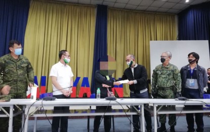 <p><strong>E-CLIP AID</strong>. Anne Margarette Tauli (3rd from left), a former ranking official of the Communist Party of the Philippines-New People's Army-National Democratic Front, receives from Baguio City Mayor Benjamin Magalong (4th from left) on Thursday the government’s cash aid under the Enhanced Comprehensive Local Integration Program. Tauli voluntarily surrendered on June 11 after she sought the help of National Security Adviser Secretary Hermogenes Esperon. <strong><em>(PNA photo by Liza T. Agoot)</em></strong></p>