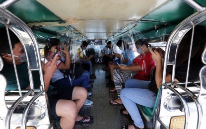 <p><strong>SPACED OUT.</strong> Passengers practice physical distancing inside a traditional public utility jeepney that has plastic barriers set up to curb the spread of the coronavirus. With the reopening of public transport services during the GCQ, passengers are reminded to wear face mask and shield. <em>(PNA photo by Joey O. Razon)</em></p>