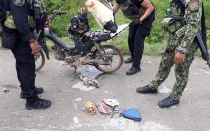 <p><strong>BOMB COMPONENTS</strong>. Police and military personnel inspect the motorcycle of slain suspected bomb courier Alimudin Unggala for bomb components after he was intercepted in the vicinity of Barangay Madia, Datu Saudi Ampatuan, Maguindanao on Friday (July 3, 2020). The suspect, an alleged close aide of Imam Bungos, a commander of the Islamic State-inspired Bangsamoro Islamic Freedom Fighters, was killed after trying to lob a grenade at government troopers. <em>(Photo courtesy of Dennis Arcon – DXMY Cotabato)</em></p>