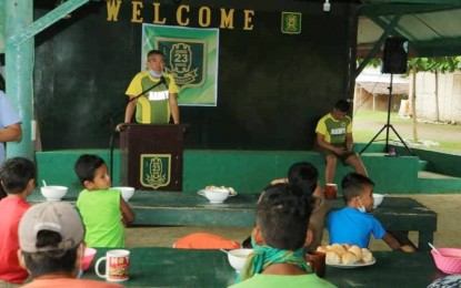<p><strong>FEEDING THE CHILDREN.</strong> Lt. Col. Julius Cesar C. Paulo (standing) commander of the Army's 23rd Infantry Battalion, leads a feeding program on Sunday (July 5, 2020) at the 23IB headquarters in Barangay Alubihid, Buenavista, Agusan del Norte. The activity benefited 27 children of former communist rebels. <em>(Photo courtesy of 23IB)</em></p>