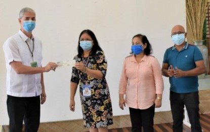 <p><strong>AID TO SCHOOLS</strong>. Negros Occidental Governor Eugenio Jose Lacson (left) turns over the check amounting to PHP9 million to Provincial Schools Division Superintendent Marsette Sabbaluca (2nd from left), in the presence of other education officials, as financial assistance for schools in three municipalities, during the Provincial School Board meeting held at the Capitol Social Hall in Bacolod City on Wednesday (July 8, 2020). The amount will be used for the upgrading of public school facilities in said towns. <em>(Photo courtesy of PIO Negros Occidental)</em></p>