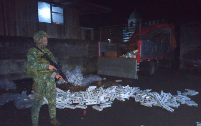 <p><strong>CONFISCATED.</strong> A Marine officer watches over smuggled cigarettes that several unidentified men were trying to haul to a safe place at the public market of Malabang, Lanao del Sur on Tuesday (July 14, 2020). More than PHP750,000 worth of smuggled cigarettes were seized but no arrest was made. <em>(Photo courtesy of MBLT-5)</em></p>
