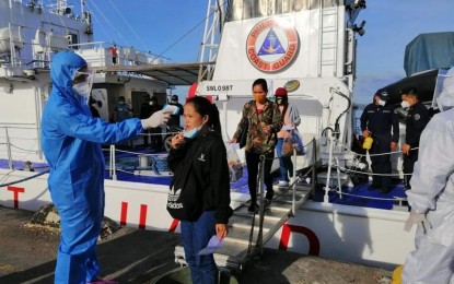 <p><strong>WORKING IN THE FRONTLINES. </strong>An officer of the Philippine Coast Guard (PCG) takes temperature readings of locally-stranded individuals (LSI) upon their disembarkation from BRP Cape Engaño in Bohol on July 13, 2020. The PCG reported on Friday (July 17, 2020) that 313 of its frontline personnel have been infected with the coronavirus disease 2019 (Covid-19). (<em>Photo courtesy of PCG</em>) </p>